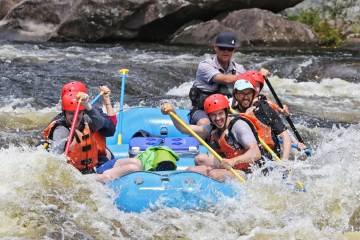 a group of people riding on a raft in a body of water