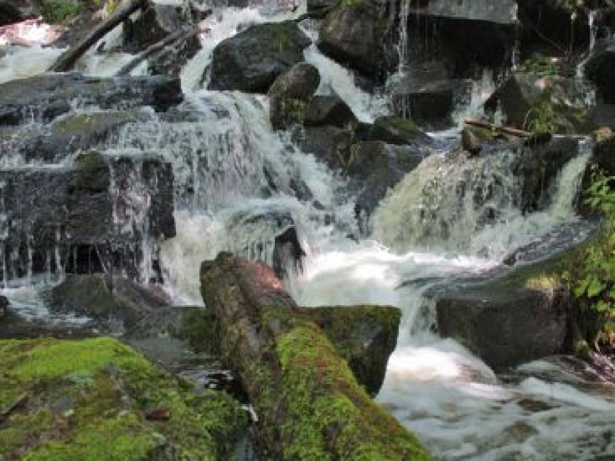 a large waterfall next to a rock