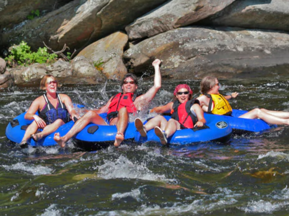 a group of people riding on the back of a boat in the water